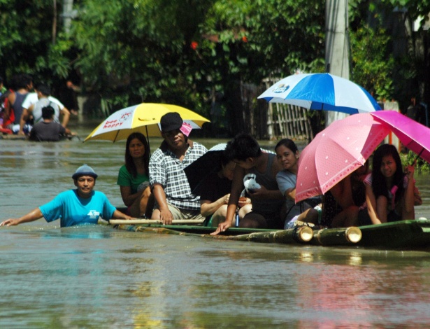 Moradores improvisam embarcação em rua inundada na aldeia de Calasiao, cidade na província de Pangasinan, ao norte de Manila, depois de fortes chuvas atingirem a região predominantemente agrícola - AFP