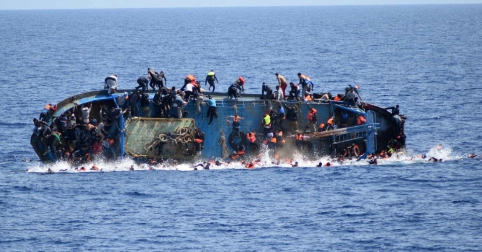 26.mai.2016 - Barco superlotado de refugiados naufraga na costa da Líbia na quarta-feira (25), mas a imagem do desastre foi divulgada nesta quinta. Pelo menos sete refugiados morreram afogados e 500 foram resgatados pela Marinha italiana. Os trabalhos de resgate continuam 