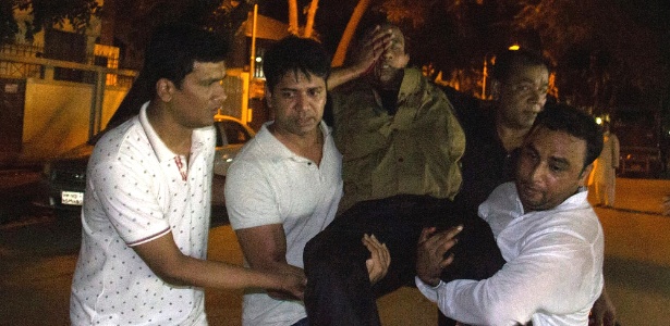 Homem ferido é carregado após atentado em Dacca, capital de Bangladesh