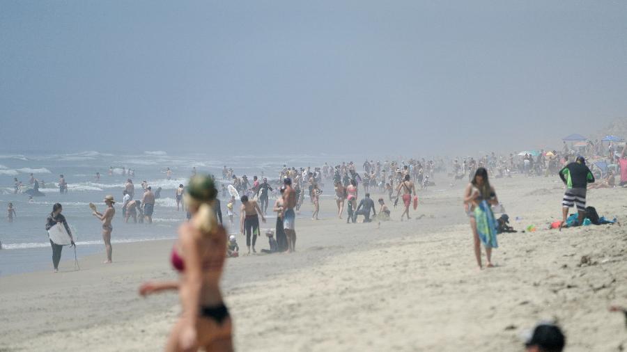Pessoas andam em praia de Huntington, sul da Califórnia, durante quarentena - Reuters