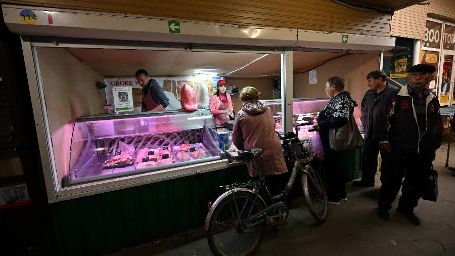 22.mai.22 - A açougueira Valeriya Bilyk, 21, e seu marido estão trabalhando no mercado reaberto em Bucha, região de Kiev - SERGEI SUPINSKY/AFP