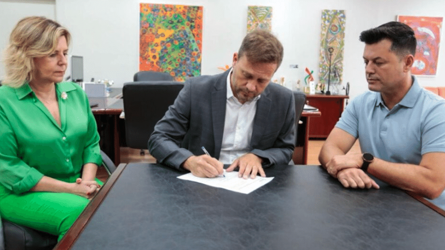 O prefeito Adriano Silva, ladeado pela vice-prefeita Rejane Gambin e o vereador Brandel Junior, durante assinatura do decreto