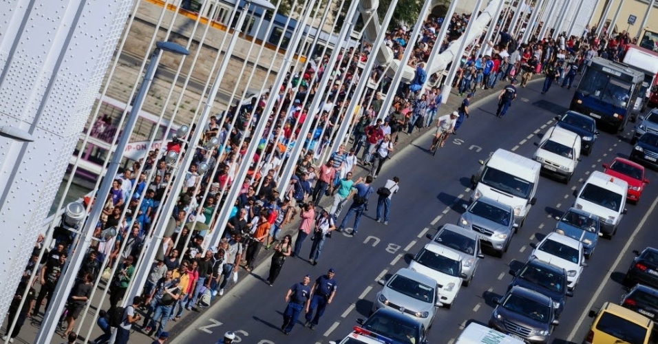 4.set.2015 - Centenas de imigrantes caminham em direção à fronteira austríaca, depois de deixarem a estação de trem de Budapeste, na Hungria. Cerca de 2.000 refugiados foram impedidos de embarcar em trens que tinham como destino a Áustria e a Alemanha