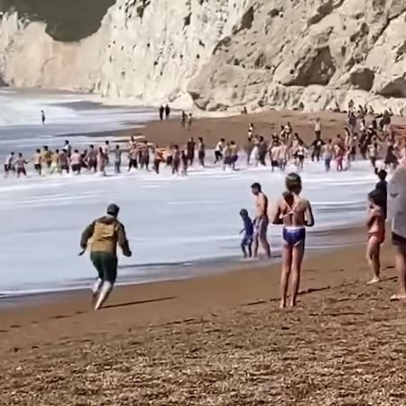 Frequentadores da praia reagiram inicialmente com incerteza, mas depois se uniram para salvar homem levado pelas águas - The Guardian/Reprodução