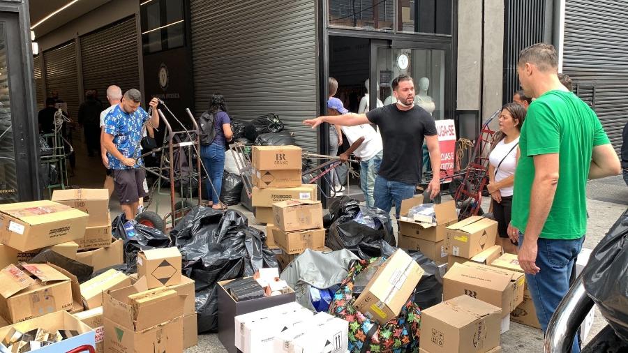 Comerciantes retiram objetos de shopping ao lado de incêndio de grandes proporções no Brás