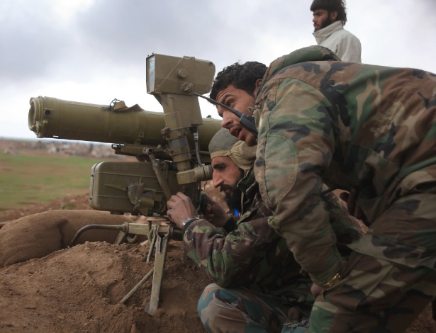 Em imagem de janeiro de 2016, forças de combate em favor do governo sírio se preparam para utilizar sistema anti-tanque em trincheira na área de Hatabat al-Bab, leste de Aleppo - George Ourfalian/AFP
