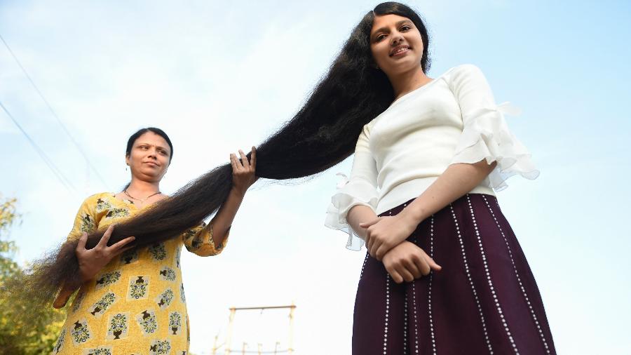 Nilanshi Patel (à dir.) recebeu o prêmio Guinness de 2019 por ter os cabelos mais longos do mundo. Sua mãe, Kaminibenat, que aparece nesta foto, ajuda a filha nos cuidados dos fios - Sam Panthaky/AFP