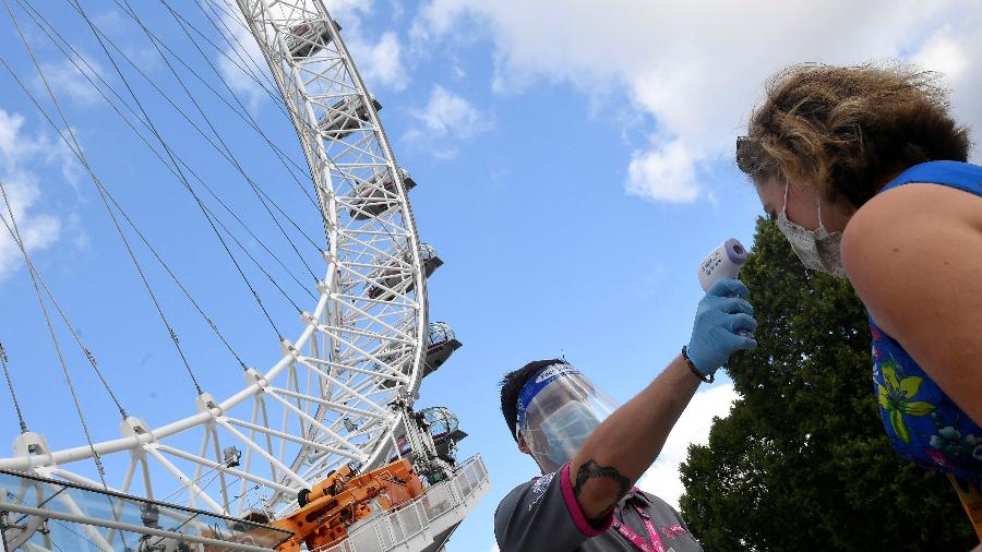 1.ago.2020 - Passageira mede a temperatura entes de embarcar na London Eye, a roda gigante mais famosa de Londres - Toby Melville/Reuters