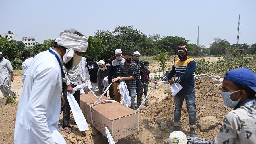 Parentes, amigos e trabalhadores do serviço funerário se preparam para enterrar vítima da covid-19 em Nova Déli, na Índia - Sajjad Hussain/AFP