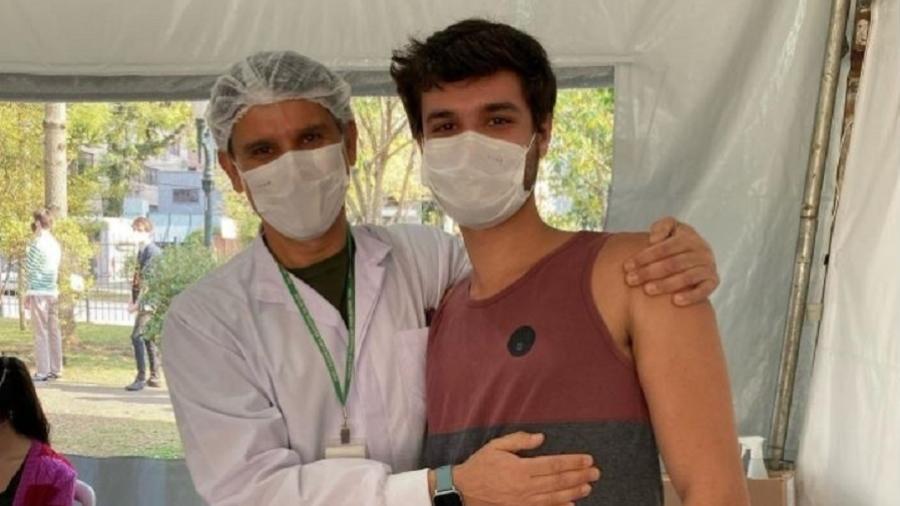 22.08.2021 -- Maurício Grzybowski Ferreira sendo vacinado pelo pai, Rogério Ferreira, em Curitiba - Reprodução