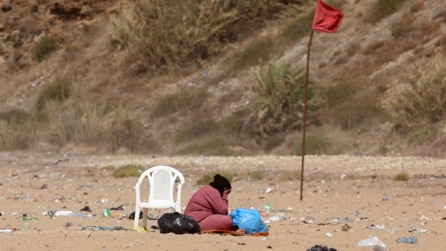 Mulher é vista na praia de Ramlet al-Baida, em Beirute; local foi transformado em campo de refugiados, segundo agência de notícias AFP