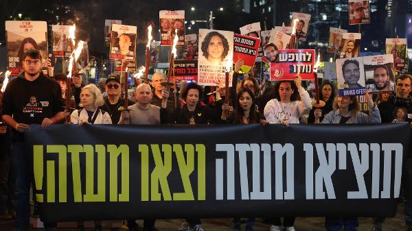 Manifestantes erguem cartazes de reféns em Gaza em ato em frente ao Ministério da Defesa de Israel