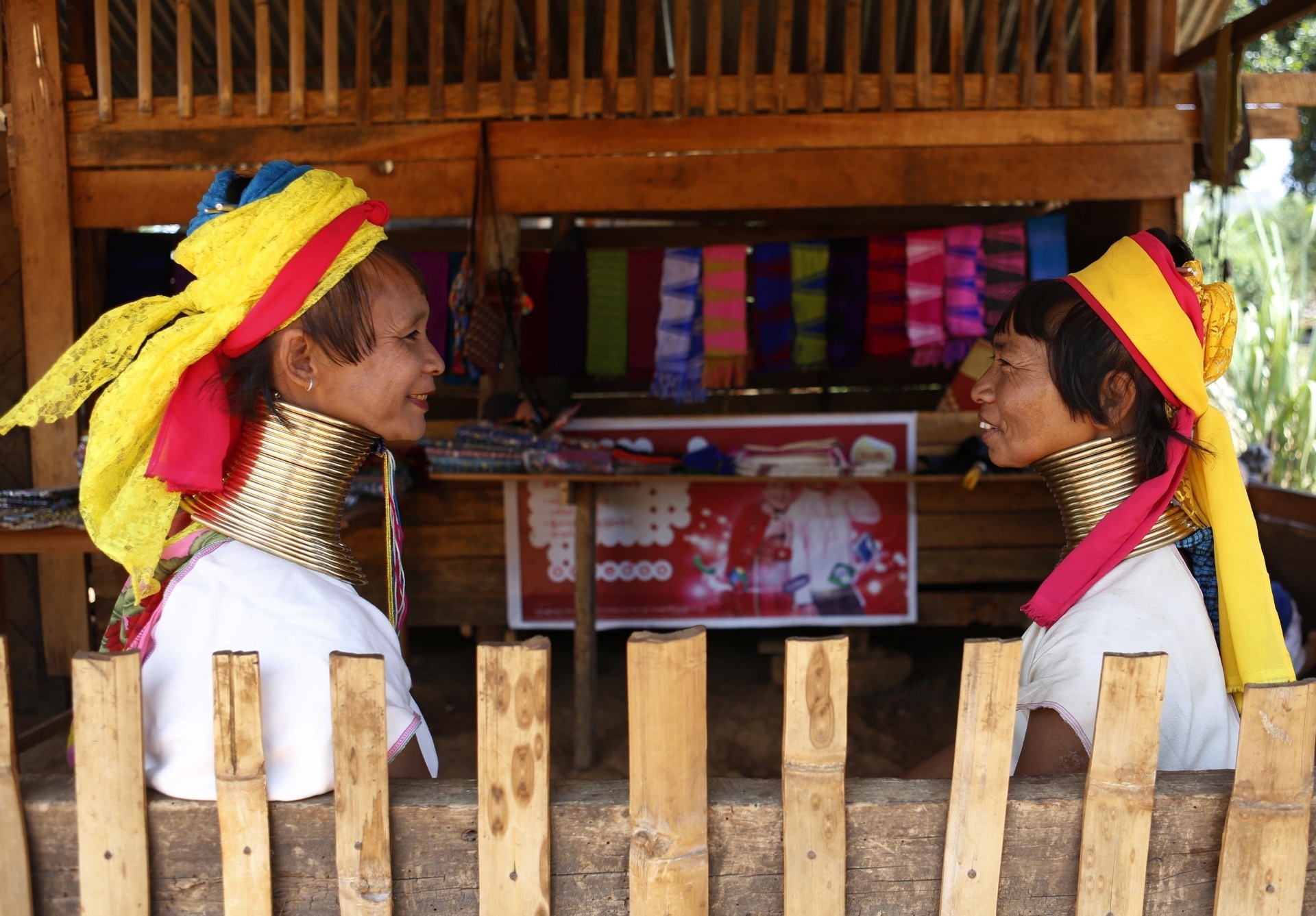 11.abr.2016 - Mulheres da tribo Padaung conversam em loja de presentes na vila Panipat, em Myanmar. Na cultura local, os primeiros anéis são colocados em volta do pescoço quando as meninas têm oito anos. Conforme as garotas vão crescendo, mais anéis vão sendo adicionados - Xinhua/U Aung