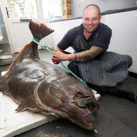 Jamie Barrett segura o seu peixe de mais de 134 quilos - Reprodução/Manchester Evening News