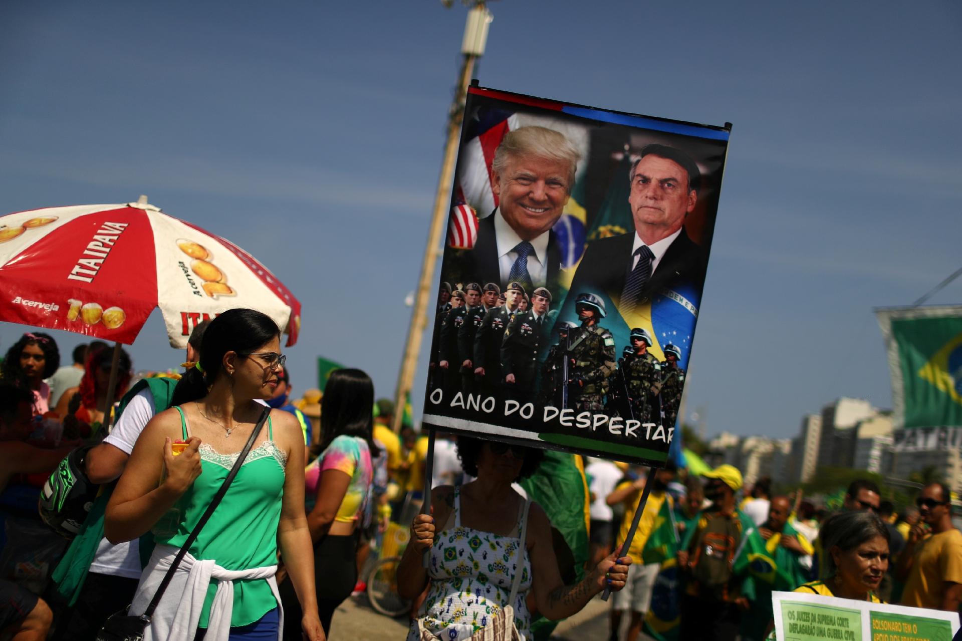 7.set.2021 - Manifestante segura cartaz de Jair Bolsonaro e Donald Trump no Rio de Janeiro - PILAR OLIVARES/REUTERS
