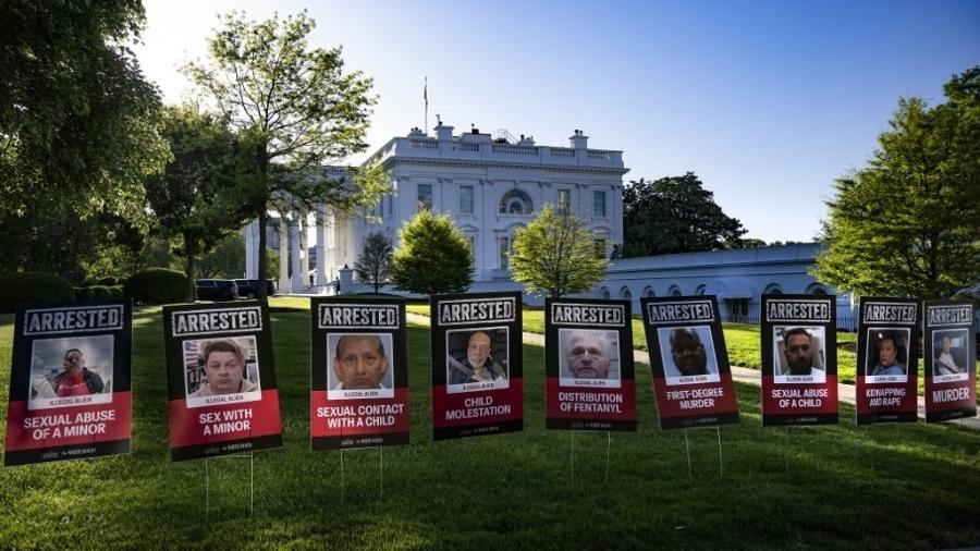 Cartazes com os rostos de imigrantes ilegais na entrada da Casa Branca em Washington, D.C., em 28 de abril de 2025 - JIM WATSON/AFP