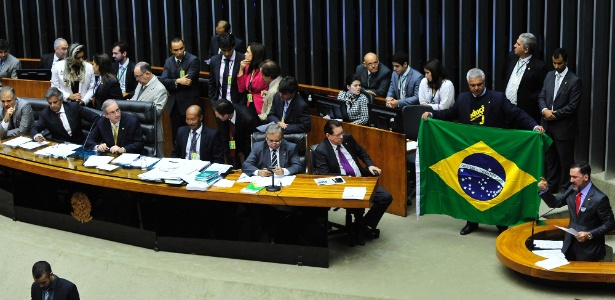Observado por Eduardo Cunha (ao centro), deputado a favor da redução da maioridade estende bandeira do Brasil - Luis Macedo - Câmara dos Deputados