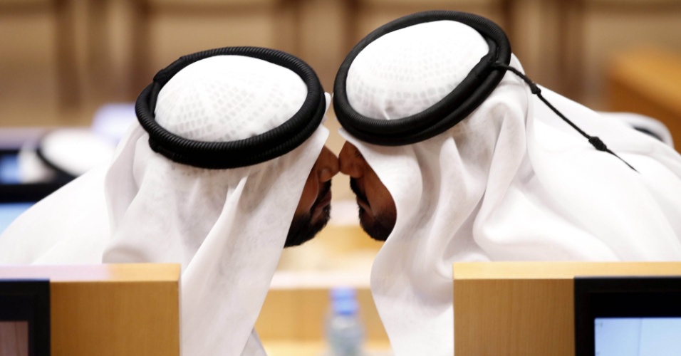 18.nov.2015 - Dois membros do Conselho Nacional Federal se cumprimentam durante sessão inaugural do novo mandato do conselho, em Abu Dhabi (Emiratos Árabes Unidos)