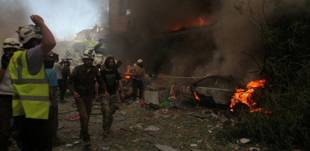 Bombeiros tentam debelar incêndios provocados por bombardeios na cidade de Idibi, na Síria