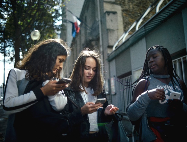 Estudantes francesas usam seus celulares após a aula, em Paris - Dmitry Kostyukov/The New York Times