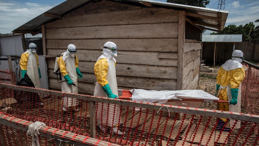Profissionais carregam o corpo de uma menina de 11 anos que morreu de ebola depois de ter sido internada em um centro de tratamento em Beni, no Congo - Finbarr O"Reilly/The New York Times