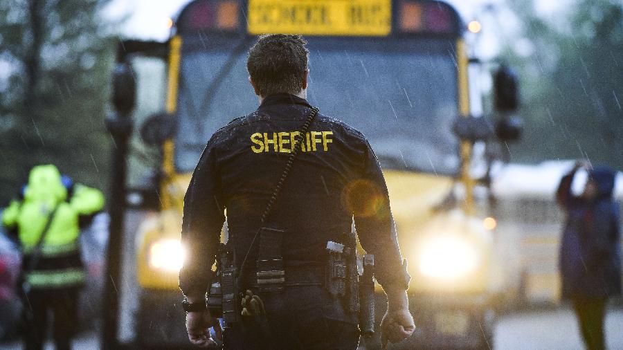 7.mai.2019 - Xerife faz segurança do local enquanto estudantes são transportados em ônibus após tiroteio em escola do Colorado, EUA - Michael Ciaglo/Getty Images/AFP