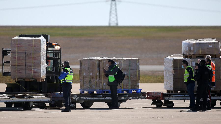 Funcionários do aeroporto descarregam avião que transportava 10 milhões de máscaras encomendadas pela França da China - François Nascimbeni/AFP