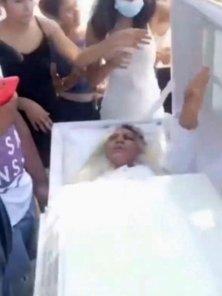 Imagem da dominicana deitada em caixão em "falso" funeral - Reprodução/Newsflash