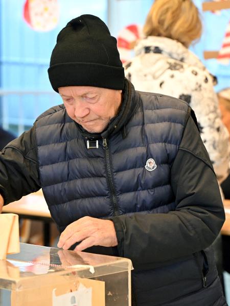 17.dez.2023 - Um eleitor deposita seu voto em uma urna em uma seção eleitoral durante as eleições parlamentares e locais na Sérvia