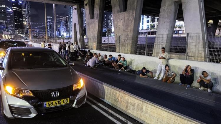 Pessoas se protegem de mísseis em Tel Aviv 