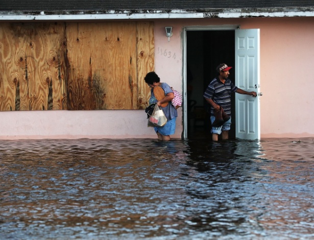 11.set.2017 - Casal se depara com enchente ao tentarem sair de casa em Fort Myers, na Flórida (EUA)). A região foi devastada pela passagem do furacão Irma  - Spencer Platt / AFP