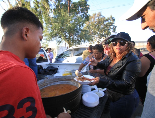 Integrantes de caravana migrante recebem alimento no ginásio Benito Juárez, em Tijuana - Joebeth Terriquez/Xinhua