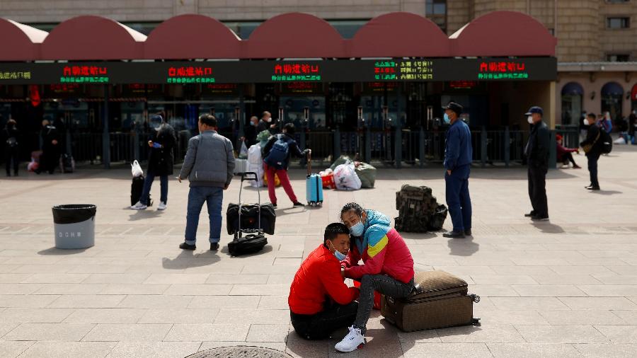 1.abr.2020 - Pessoas usando máscara protetiva contra o coronavírus esperam do lado de fora da Estação Ferroviária de Pequim, na China - Thomas Peter/Reuters