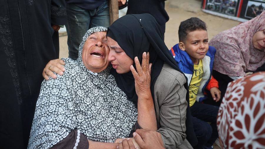 Palestinos lamentam parentes mortos em um ataque israelense a tendas de deslocados nas proximidades, no hospital dos Mártires de Al Aqsa, em Deir el-Balah - Eyad BABA / AFP