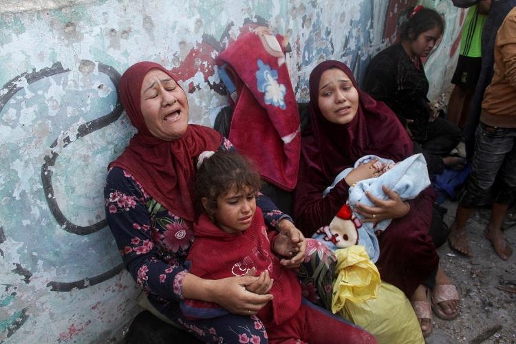 Mulheres e crianças palestinas choram após abrigo para refugiados em escola ser atingido por bombardeio israelense na Cidade de Gaza