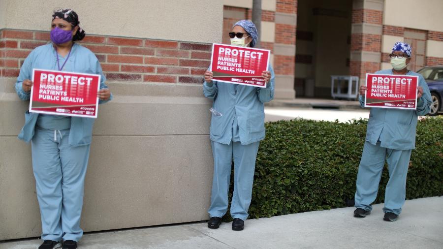 Enfermeiras e profissionais de saúde se distanciam socialmente enquanto protestam por equipamentos de proteção individual em Los Angeles, Califórnia, EUA - LUCY NICHOLSON/REUTERS