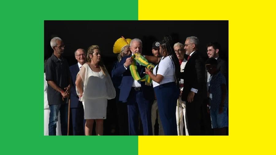 No momento mais emocionante do dia da posse, Lula recebe a faixa presidencial das mãos da catadora Aline Sousa. Ausência de Bolsonaro iluminou a cerimônia - Carl de Souza/AFP