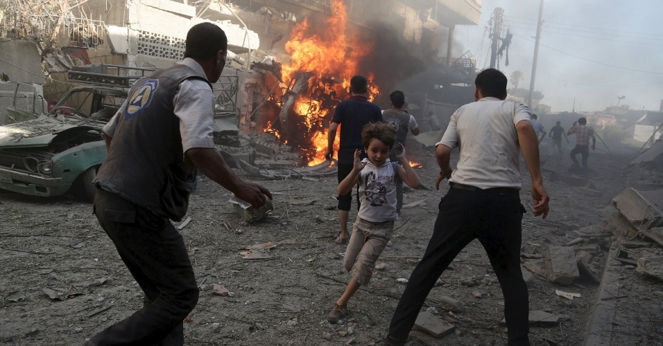 14.ago.2015 - Garoto corre de local onde houve um ataque aéreo realizado por forças leais ao presidente sírio, Bashar al-Assad, em Douma, Damasco 