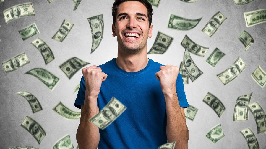 chuva de dinheiro, homem rico, jovem, prosperidade, economia, investimento, ganhar na loteria - Getty Images/iStockphoto