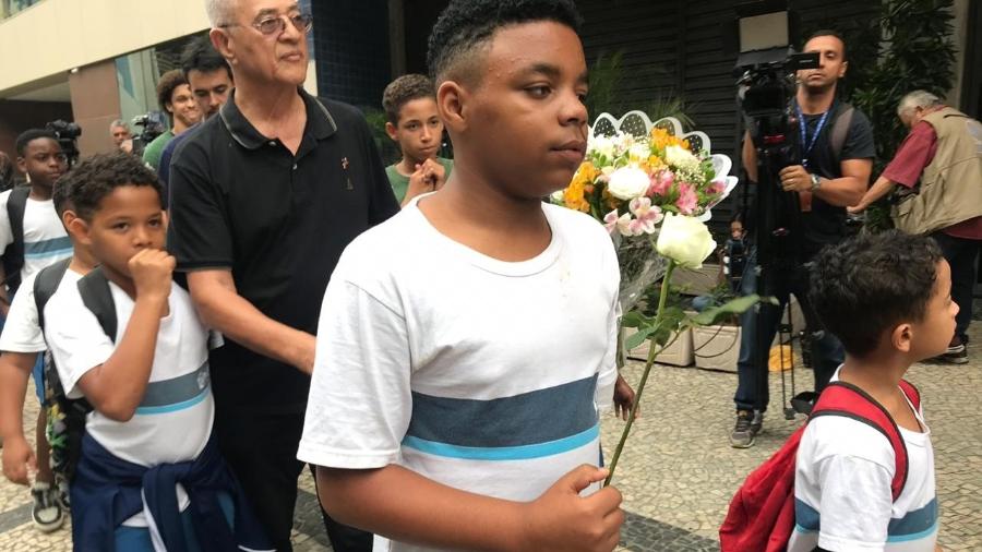 13.set.2019 - Crianças levam flores em homenagem a mortos no incêndio do Hospital Badim, no Rio - Lola Ferreira/UOL