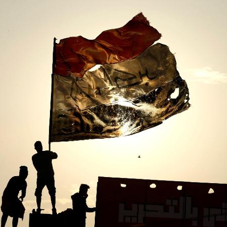 10.dez.2019 - Manifestante segura bandeira do Iraque durante protesto em Bagdá - Alaa al-Marjani/Reuters