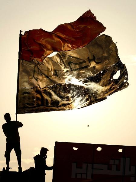 10.dez.2019 - Manifestante segura bandeira do Iraque durante protesto em Bagdá - Alaa al-Marjani/Reuters