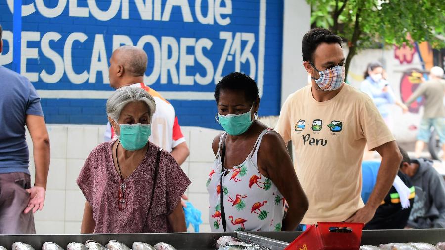 Moradores usam máscaras em área de comércio em Copacabana - PETER ILICCIEV/ ESTADÃO CONTEÚDO