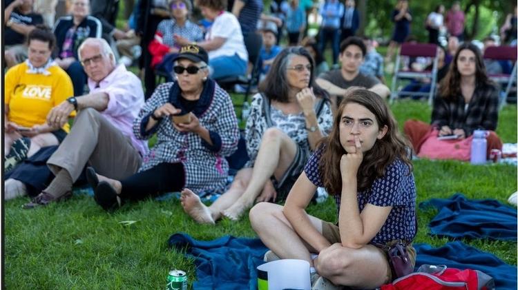 Residents of the US capital, Washington DC, watch the Congressional Hearing on the big screen in a city park - Getty Images - Getty Images