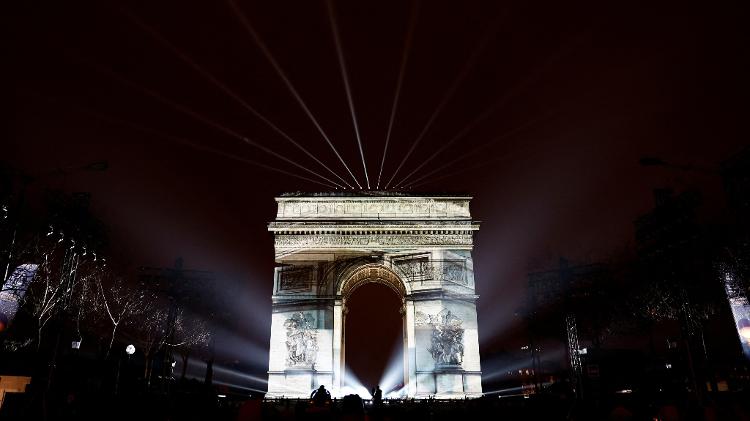 Uma imagem é projetada no Arco do Triunfo, durante as celebrações de Ano-Novo na avenida Champs-Élysées, em Paris, França.