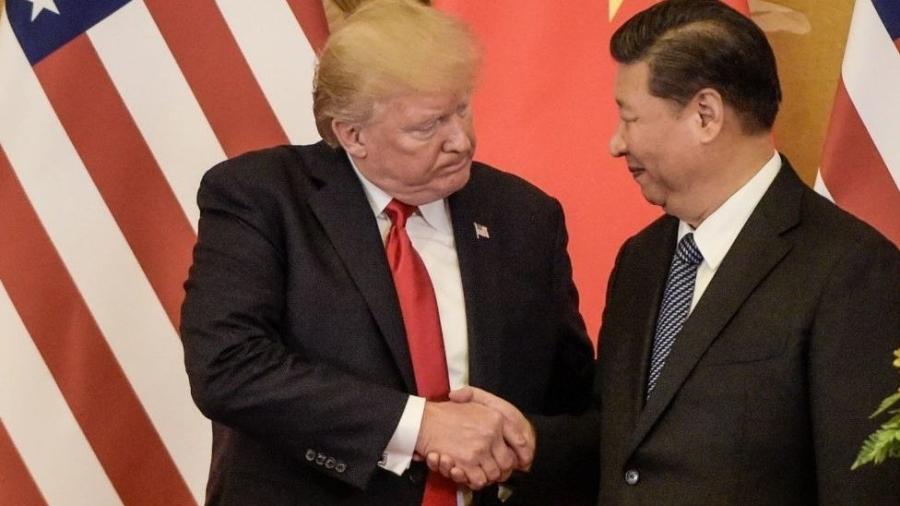 Donald Trump, retratado aqui ao lado do presidente Xi Jinping, apresenta a China como uma ameaça aos EUA - Getty Images