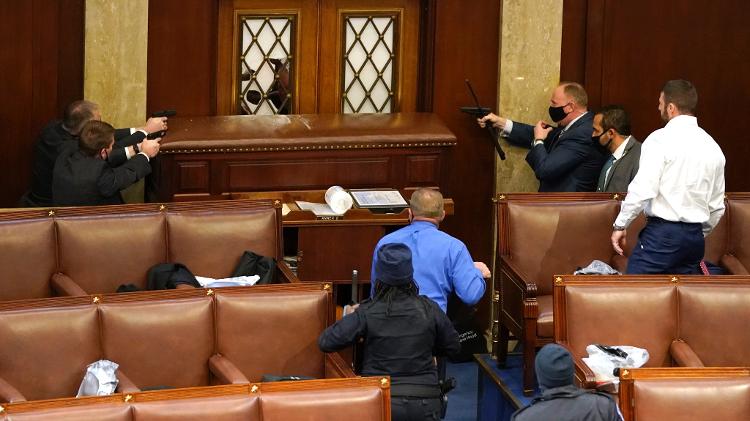 06 jan. 2021 - Policiais apontam armas para impedir que manifestantes avancem no Congresso dos Estados Unidos - Drew Angerer/Getty Images - Drew Angerer/Getty Images