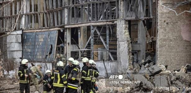 22.mar.2022- Bombeiros sentam-se em meio a escombros na área da Academia Nacional de Ciências da Ucrânia, em Kiev