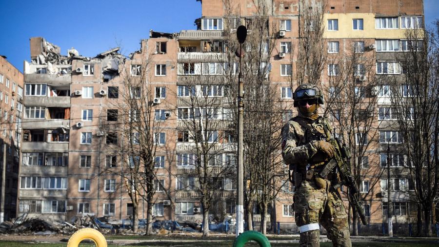 11.abr.2022 - Um soldado russo na frente de um prédio residencial destruído - ALEXANDER NEMENOV / AFP