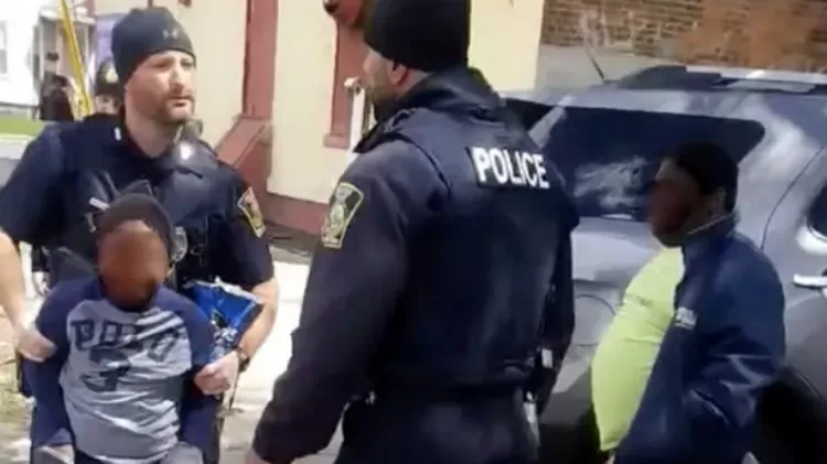 Policial captura criança pelos braços após ser acusada de roubar snacks em loja.  - Reprodução/Facebook - Reprodução/Facebook